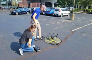 two people watching a drone that is on the ground