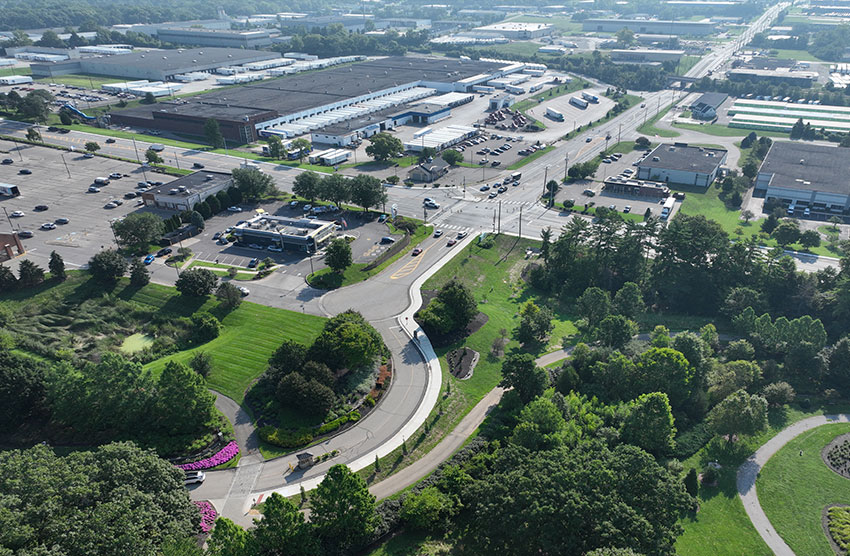 an overhead view of green trees, roads and other development